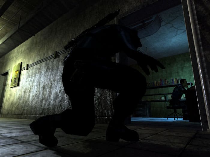 게임의 스크린 샷 Tom Clancy의 Splinter Cell Chaos 이론은 책상에서 남자와 함께 방으로 몰래 들어가는 남자를 보여주는 남자를 보여주는 남자를 보여줍니다.