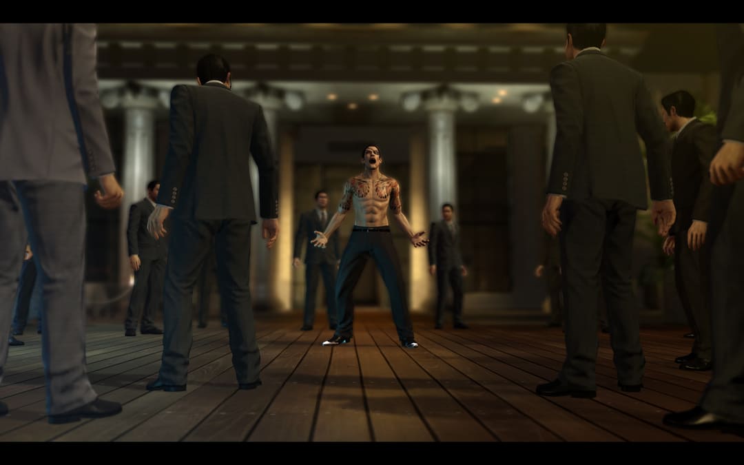 게임 Yakuza 0의 스크린 샷 6 팩 복근이있는 셔츠리스 남자와 많은 남자의 한가운데서 비명을 지르는 셔츠가없는 남자를 보여줍니다.
