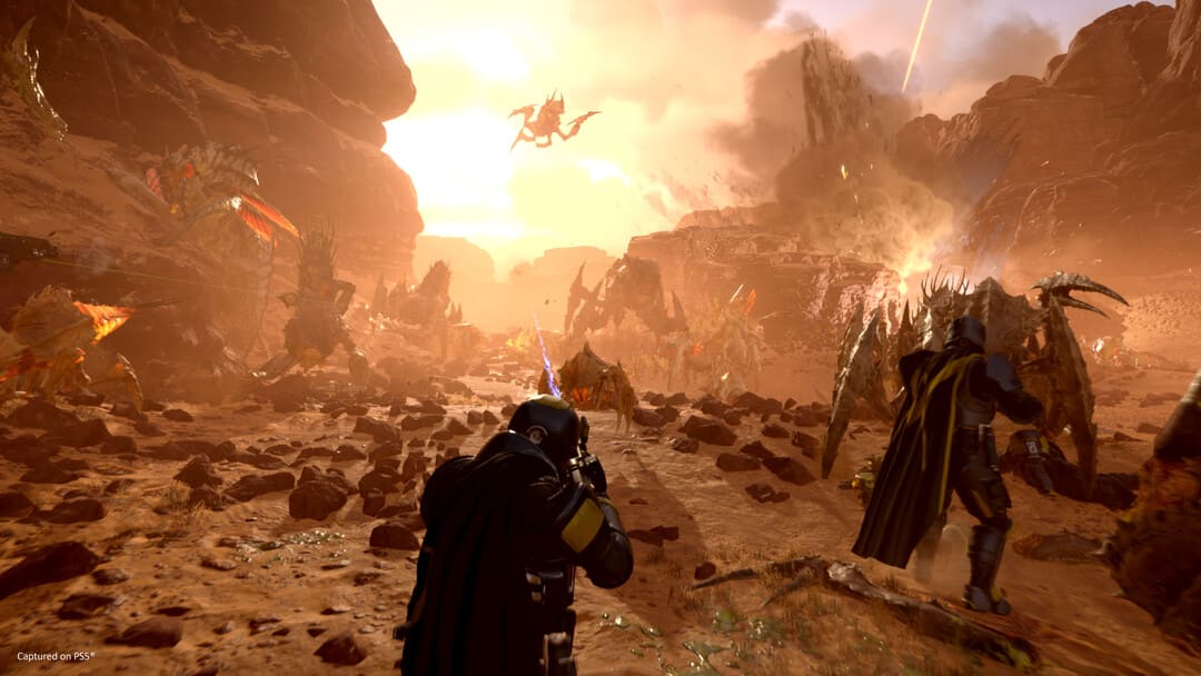 Game Helldivers 2의 스크린 샷 2 인간과 곤충 사이의 화성과 같은 행성에 대한 공격을 보여주고 배경에 폭발