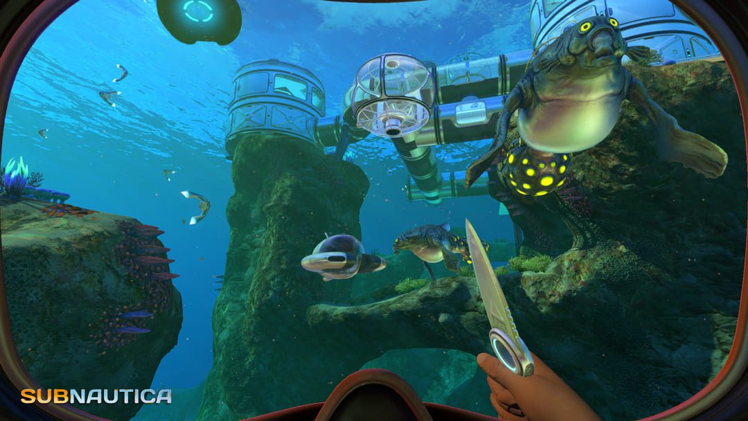 게임 Subnautica의 스크린 샷은 외계인 물고기와 산호초 위에 지어진 기지를 바라 보는 수중 다이버의 관점을 보여주는 스크린 샷